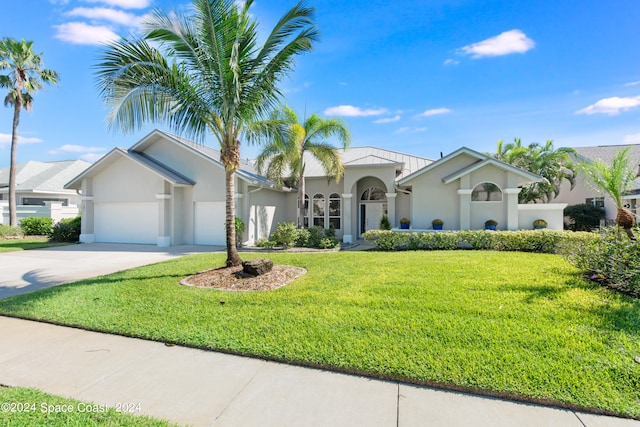 mediterranean / spanish-style home featuring a garage and a front lawn