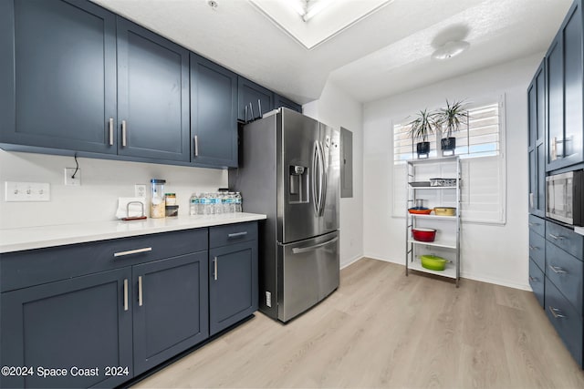 kitchen featuring blue cabinetry, electric panel, appliances with stainless steel finishes, and light hardwood / wood-style flooring