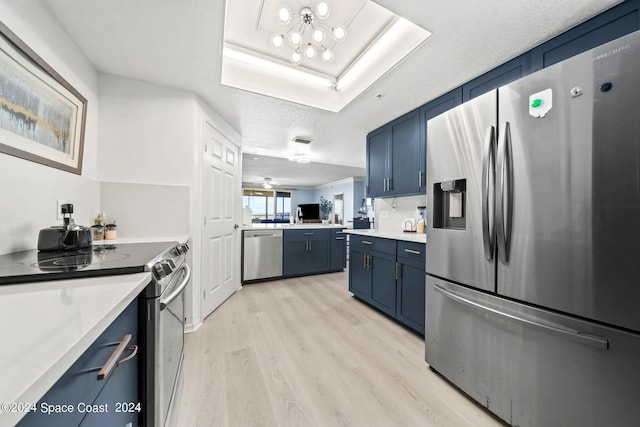 kitchen with blue cabinetry, a textured ceiling, appliances with stainless steel finishes, and light hardwood / wood-style floors