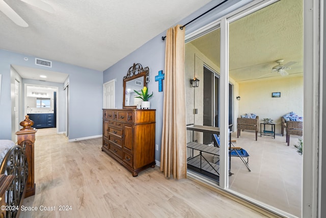 hall featuring a textured ceiling and light hardwood / wood-style floors