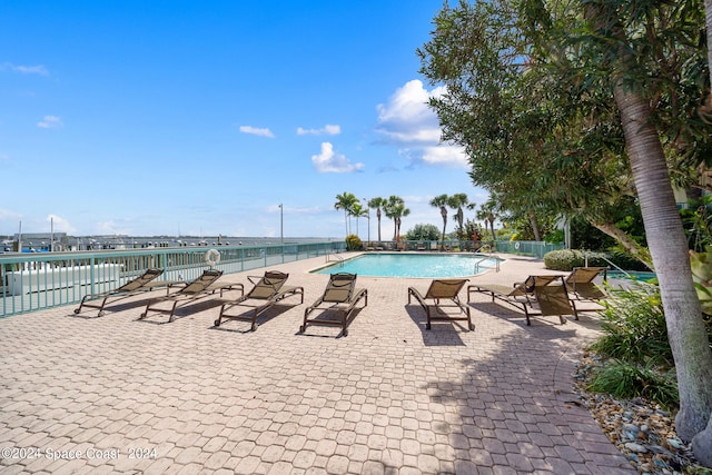 view of pool featuring a patio and a water view