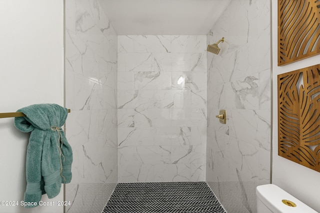 bathroom with tiled shower and toilet