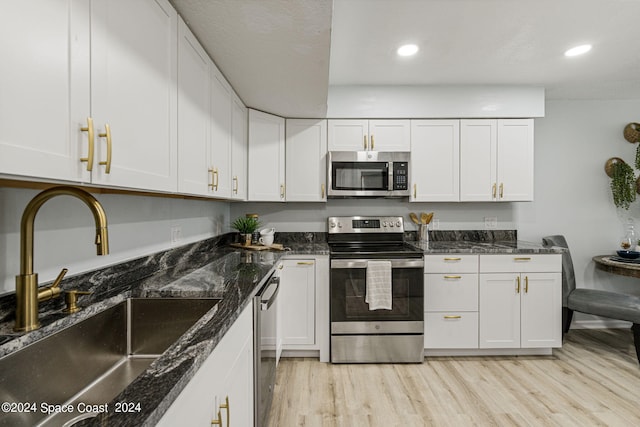 kitchen with white cabinets, light wood-type flooring, sink, and appliances with stainless steel finishes