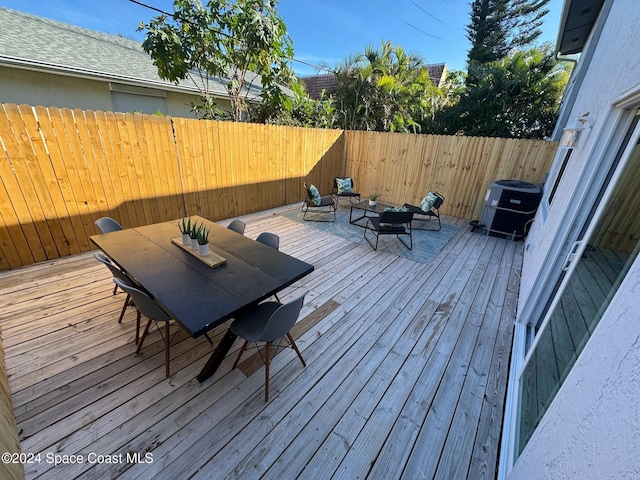 wooden terrace featuring an outdoor hangout area and central AC