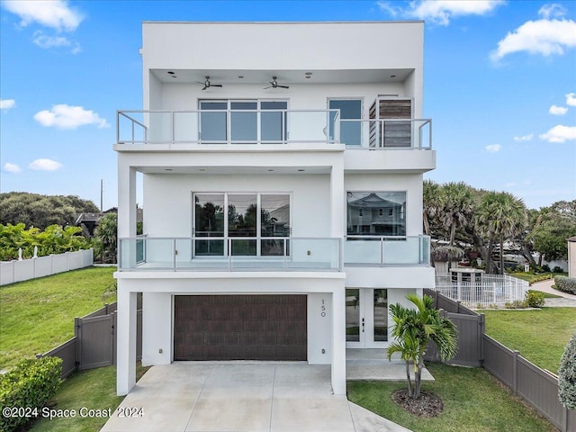 modern home with french doors, a garage, a balcony, a front yard, and ceiling fan