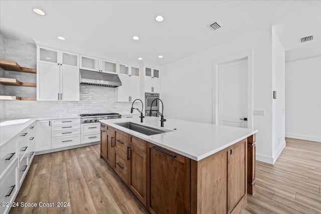 kitchen featuring appliances with stainless steel finishes, sink, a center island with sink, and white cabinets