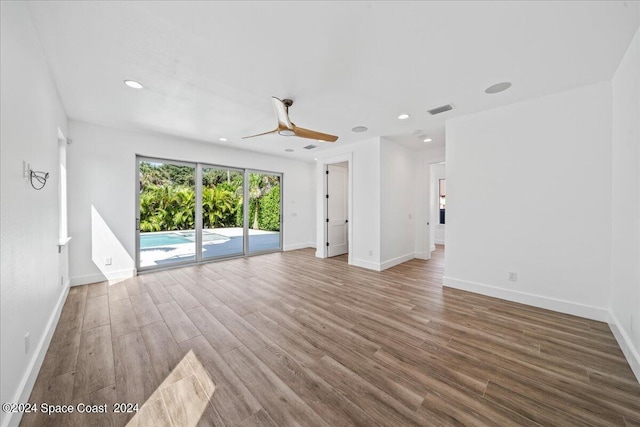 unfurnished living room with wood-type flooring and ceiling fan