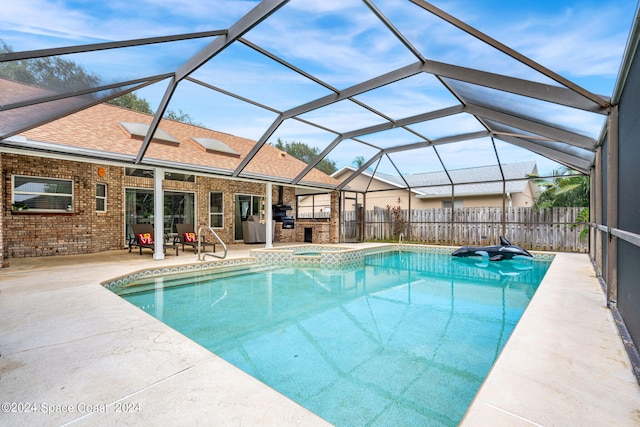 view of swimming pool featuring an in ground hot tub, a lanai, and a patio area