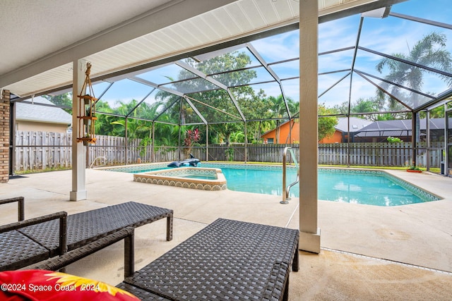 view of swimming pool featuring a lanai, an in ground hot tub, and a patio area