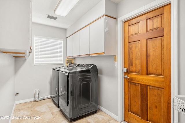 washroom with washer and clothes dryer and cabinets