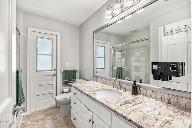 bathroom featuring a textured ceiling, walk in shower, vanity, and toilet