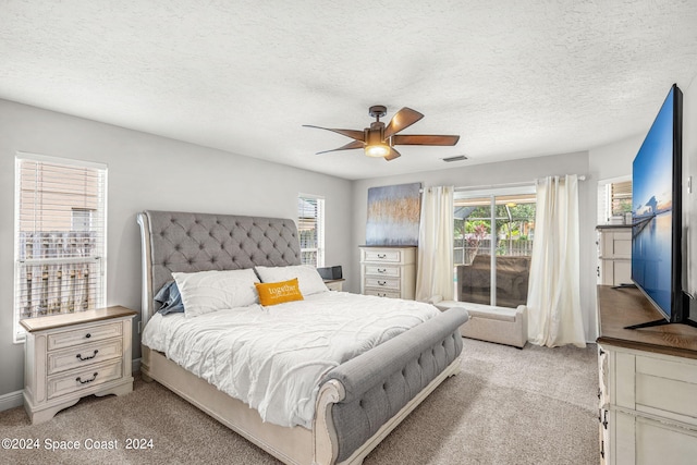 bedroom with a textured ceiling, light carpet, and ceiling fan