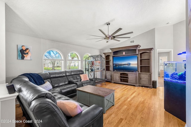 living room with wood-type flooring, vaulted ceiling, ceiling fan, and a textured ceiling