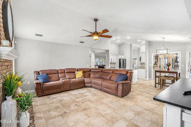 living room featuring a textured ceiling, ceiling fan with notable chandelier, and vaulted ceiling