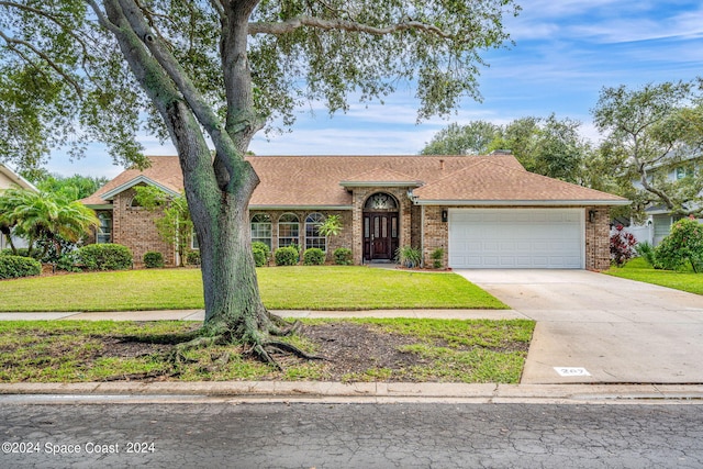 single story home featuring a front yard and a garage