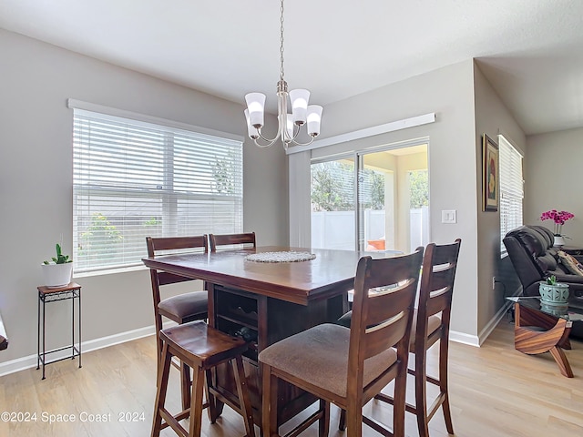 dining space with a notable chandelier, light hardwood / wood-style floors, and a wealth of natural light