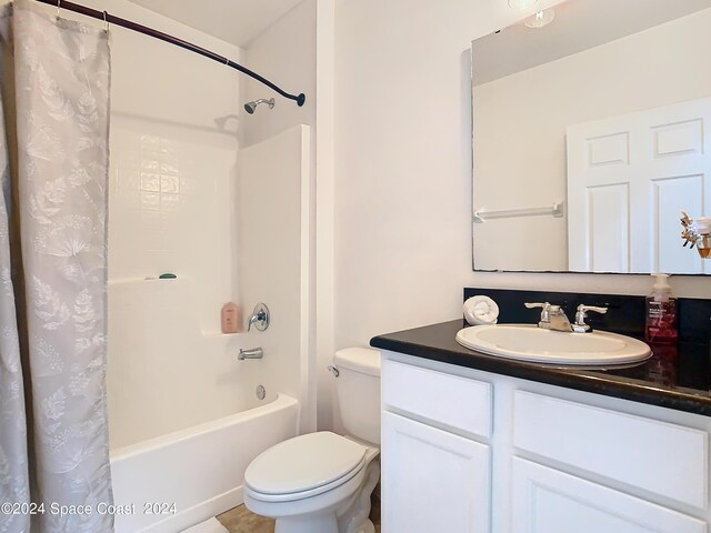 full bathroom with vanity, shower / bath combo with shower curtain, and toilet