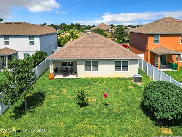 rear view of house featuring a lawn, a patio, and central AC unit