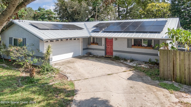 view of front facade with a garage and solar panels