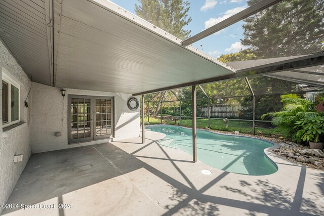 view of pool with a patio and glass enclosure