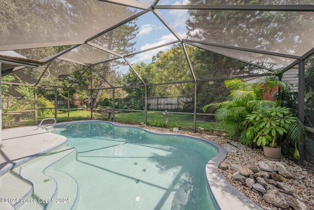 view of pool featuring glass enclosure