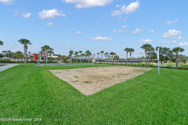 view of community with volleyball court and a lawn