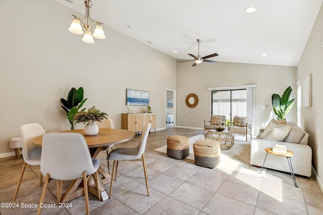 dining space featuring ceiling fan with notable chandelier, light tile patterned floors, and high vaulted ceiling