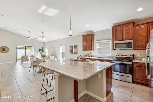 kitchen featuring pendant lighting, sink, an island with sink, appliances with stainless steel finishes, and a breakfast bar area