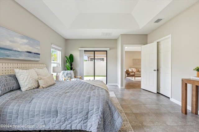 bedroom featuring access to outside and a tray ceiling