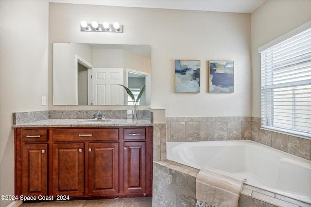 bathroom with vanity and a relaxing tiled tub