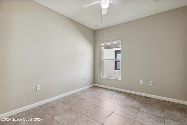 empty room with ceiling fan and light tile patterned floors