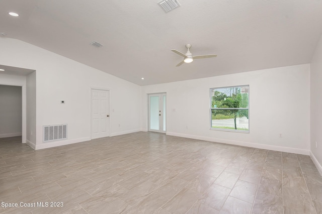 unfurnished room with a ceiling fan, baseboards, lofted ceiling, and visible vents