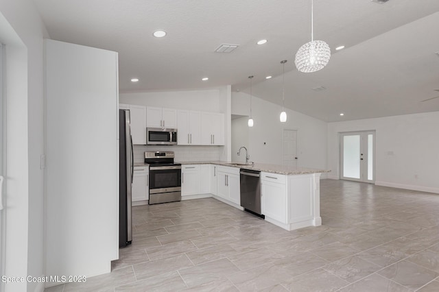kitchen featuring light stone counters, a sink, appliances with stainless steel finishes, a peninsula, and open floor plan