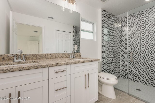 bathroom featuring a textured ceiling, a shower, vanity, and toilet