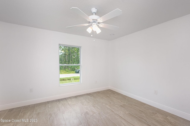 unfurnished room featuring a ceiling fan and baseboards