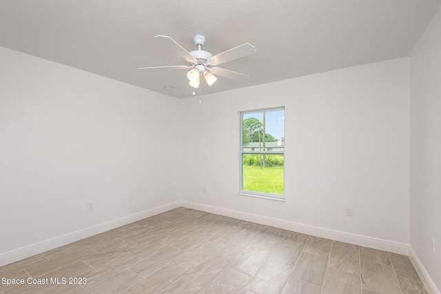 unfurnished room with baseboards and a ceiling fan