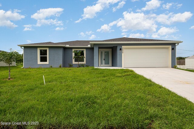 ranch-style house with a garage and a front lawn