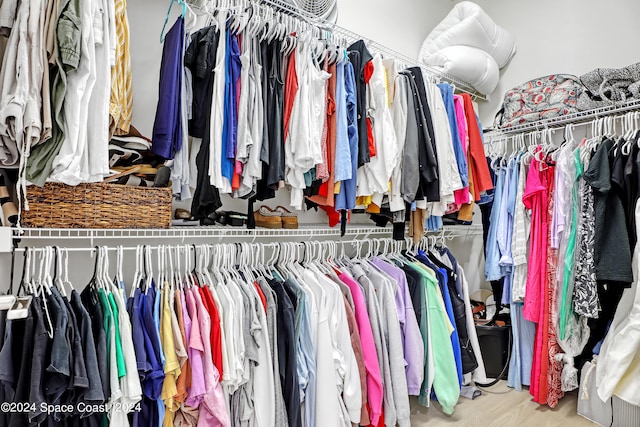 walk in closet with hardwood / wood-style flooring