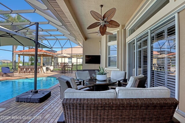 view of patio / terrace featuring a lanai, ceiling fan, and an outdoor hangout area