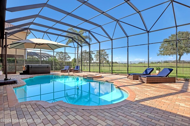 view of swimming pool with a lanai, a patio area, and a hot tub