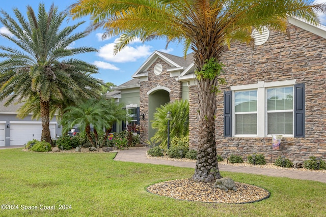 view of front of home with a garage and a front lawn