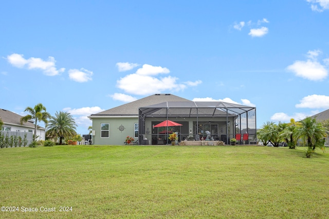 rear view of house featuring a patio, a yard, and a lanai