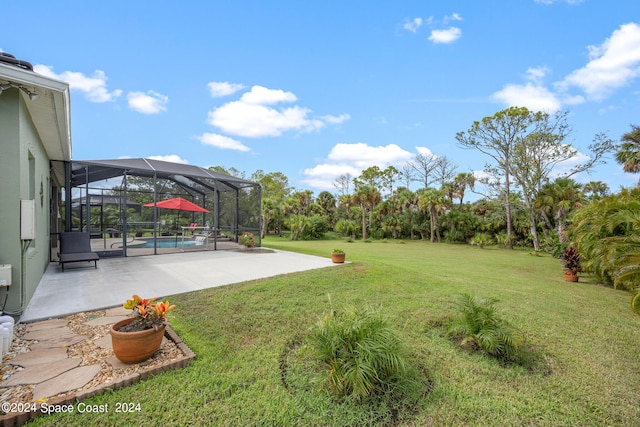 view of yard featuring glass enclosure and a patio