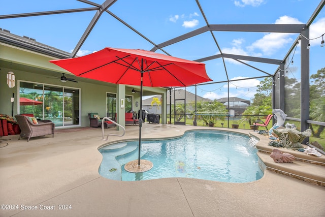 view of swimming pool with a lanai, pool water feature, a patio area, and ceiling fan