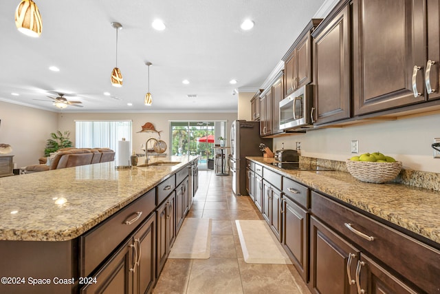 kitchen featuring a large island, sink, hanging light fixtures, appliances with stainless steel finishes, and ornamental molding