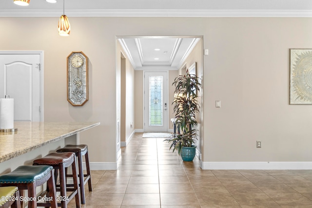 foyer with ornamental molding and light tile patterned floors