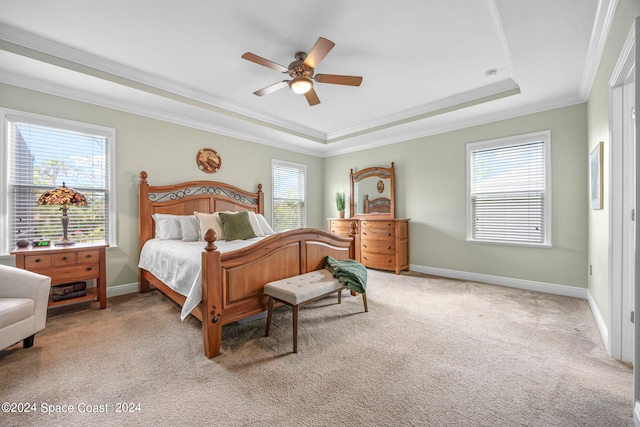 bedroom featuring a tray ceiling, ceiling fan, light colored carpet, and crown molding