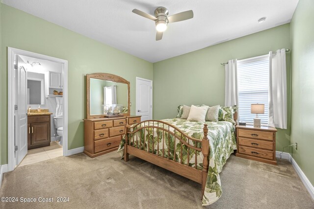 bedroom with light carpet, ceiling fan, and ensuite bathroom