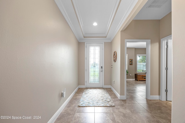 foyer entrance with a tray ceiling, plenty of natural light, light tile patterned floors, and crown molding