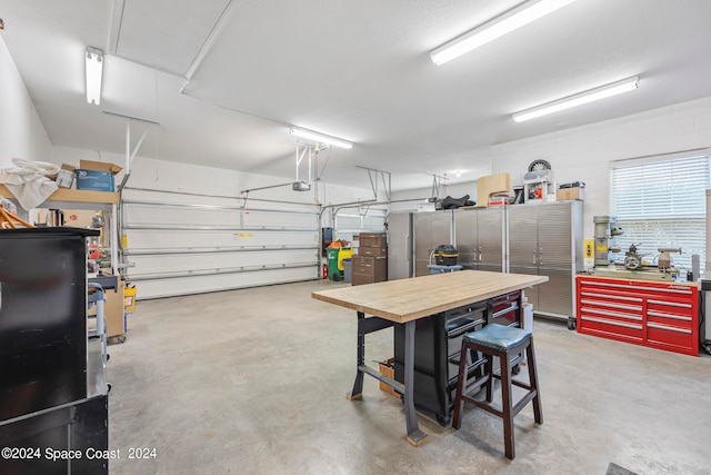 garage with a garage door opener and a workshop area